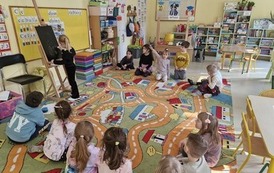 Grupa obserwuje koleżankę prezentującą zagadkę graficzną