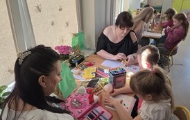 rodzice i dzieci ozdabiaja swoje marzanny