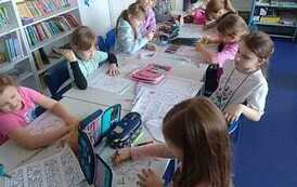 Dziewczynki z Koła Bibliotecznego rozwiązują karty pracy