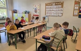 dzieci w grupach rozwiazuja quiz o segregacji smieci