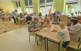 dzieci i goście przygotowują sałatkę owocową
