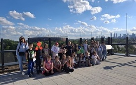 Uczniowie klasy 2A wraz z wychowawczynią na tarasie widokowym - w tle widok na panoramę Warszawy - Pałac Kultury i Nauki oraz Stadion Narodowy PGE