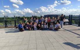Uczniowie klasy 2B wraz z wychowawczyniń&Ouml; na tarasie widokowym - w tle widok na Stadion Narodowy PGE