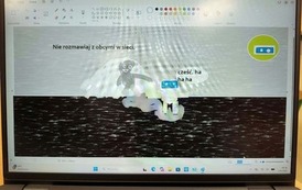 Na ekranie laptopa widoczna jest prezentacja dotycząca bezpiecznego korzystania z Internetu, w tym kontakt&oacute;w z nieznajomymi w sieci