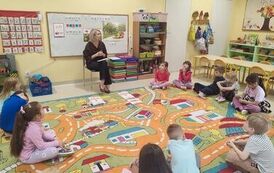 dzieci siedzą na dywanie i rozmawiają z Panią Olą