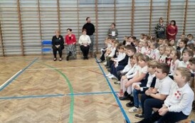 Zgromadzeni uczniowie, nauczyciele i dyrekcja szkoły w sali gimnastycznej