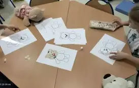 Dzieci wyklejają misia