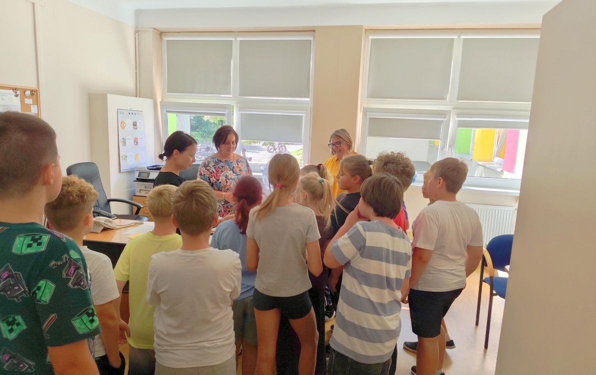 Grupa uczniów klasy 3C przekazuje pracownikom szkoły przygotowane przez siebie karteczki z dobrymi słowami.