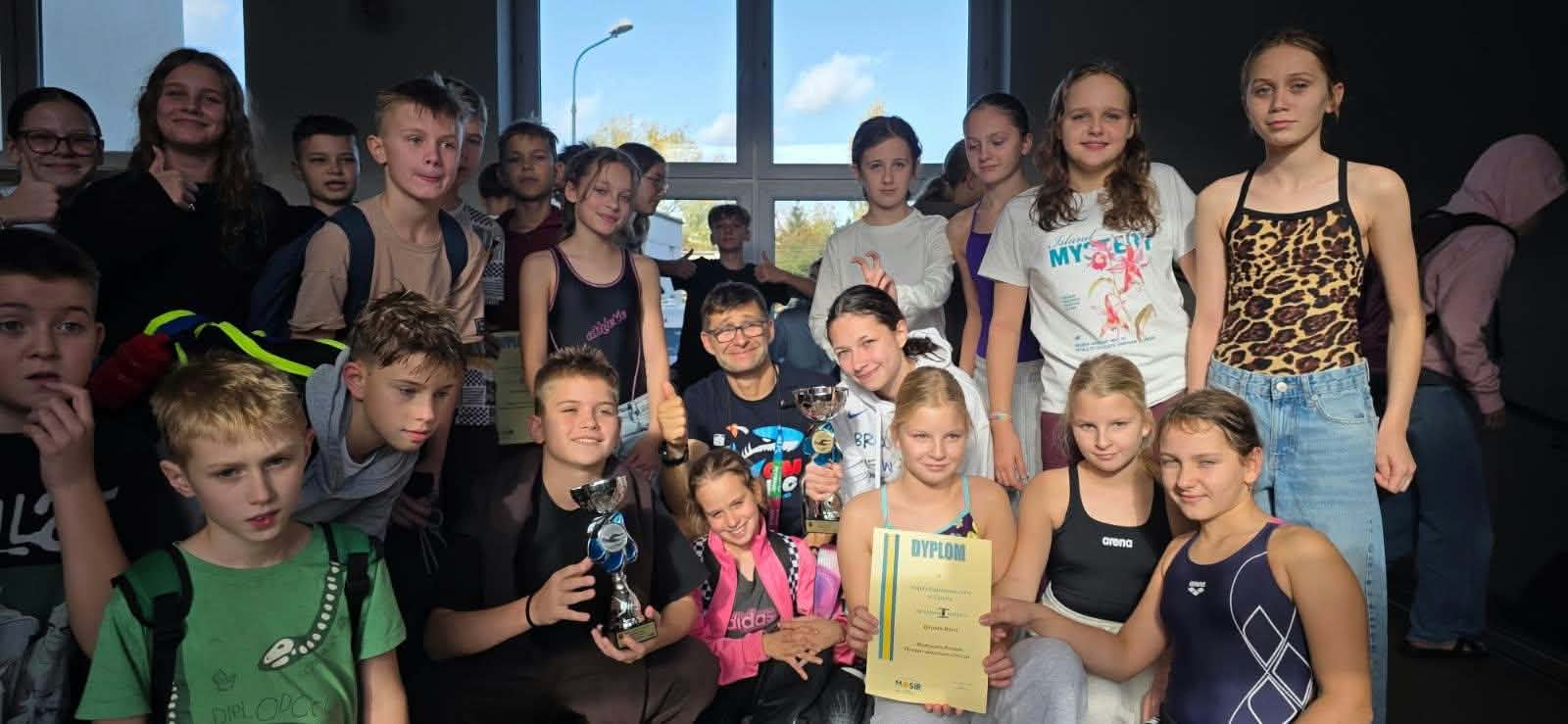 Grupa młodzieży reprezentująca szkołę z nauczycielem