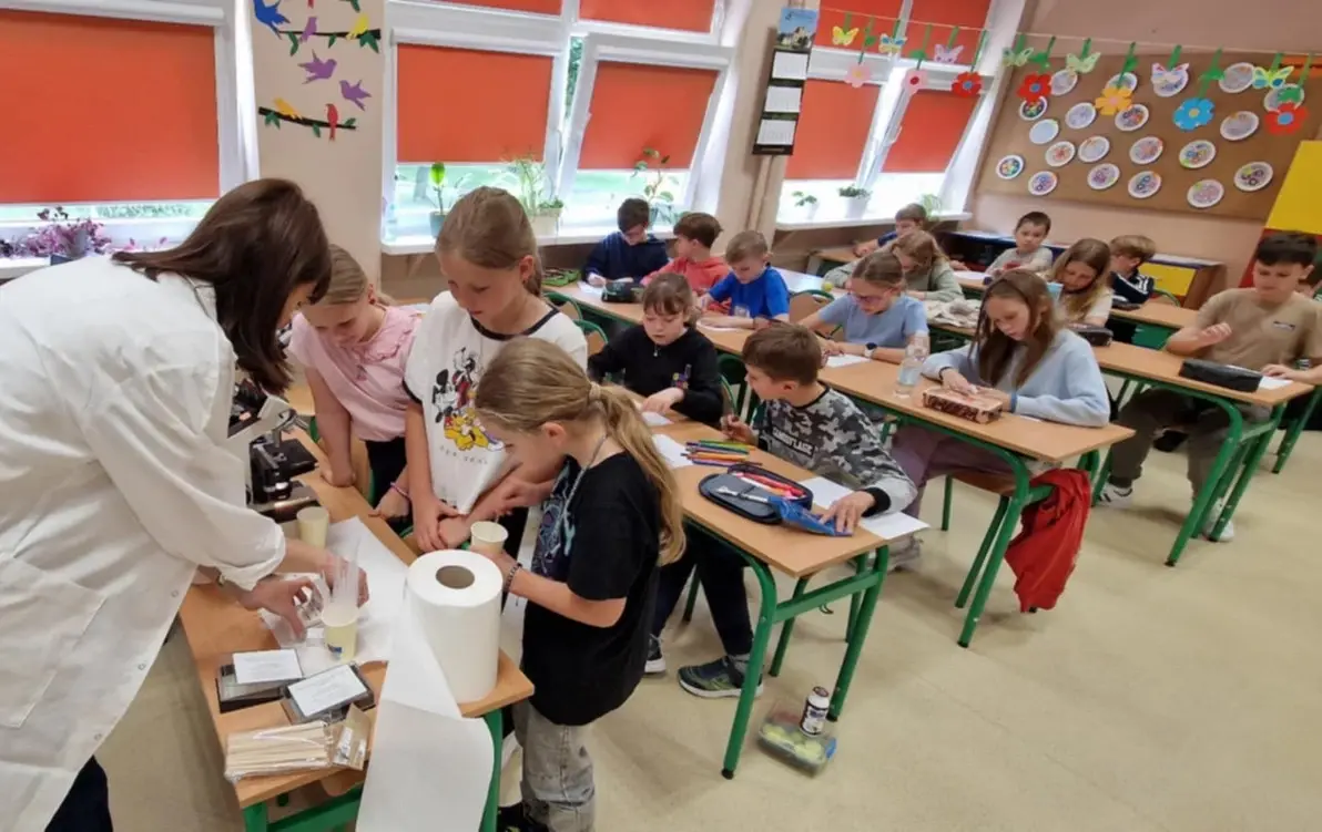 uczniowie przygotowują próbkę do badania pod mikroskopem