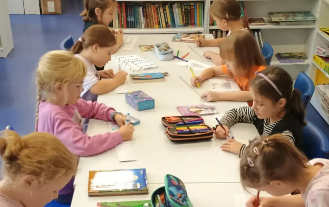 Dziewczynki z klas pierwszych tworzące zakładki do książek na zajęciach Szkolnego Koła Bibliotecznego