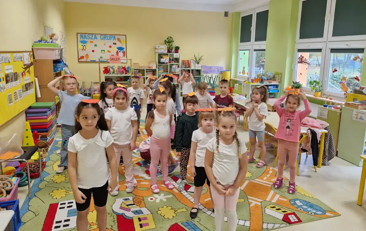 przedszkolaki ćwiczą równowagę z liściem na głowie