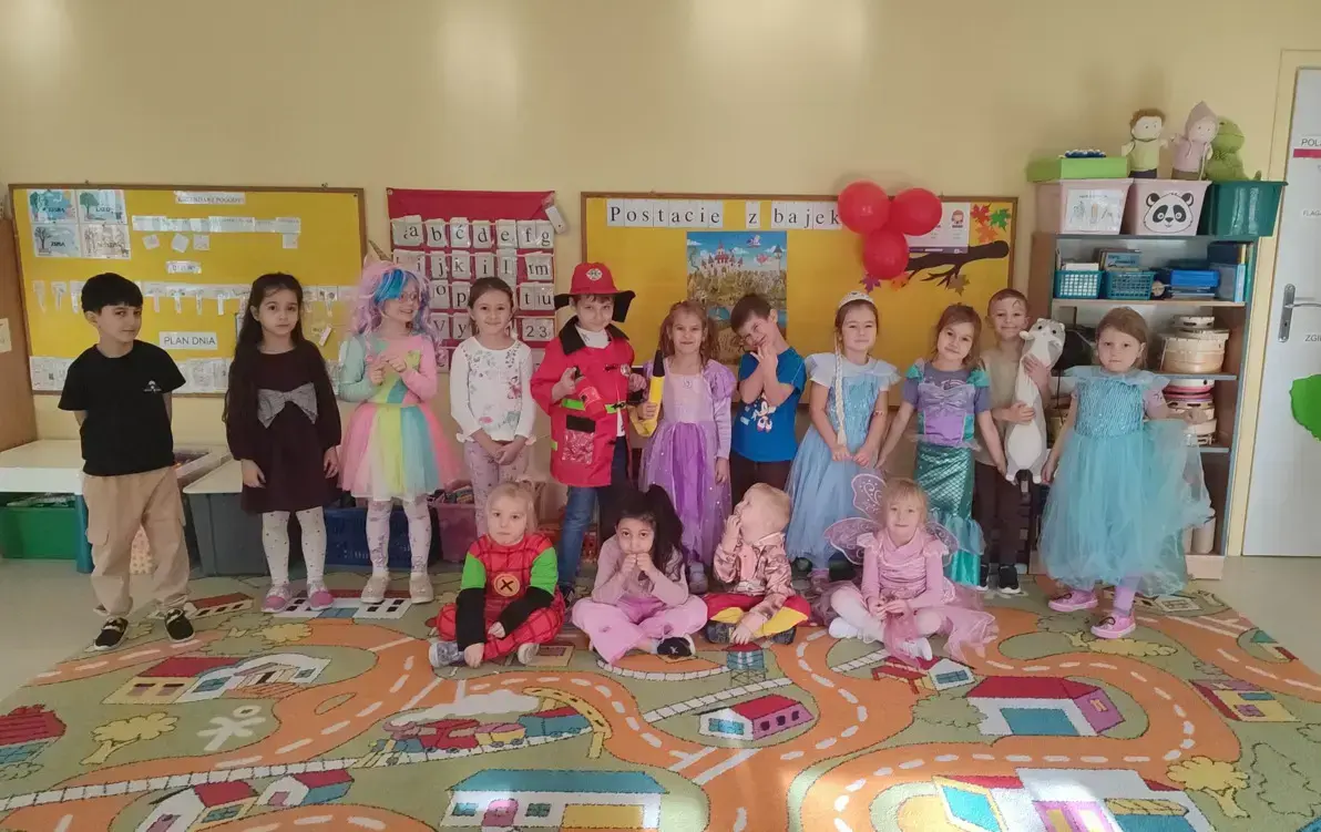 grupa przedszkola pozuje do zdjecia w bajkowych strojach