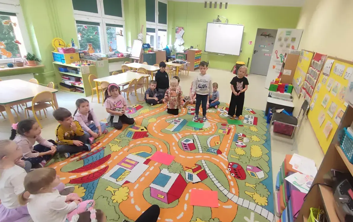 przedszkolaki siedzą na dywanie i bawią się w zabawę prawa- fałsz