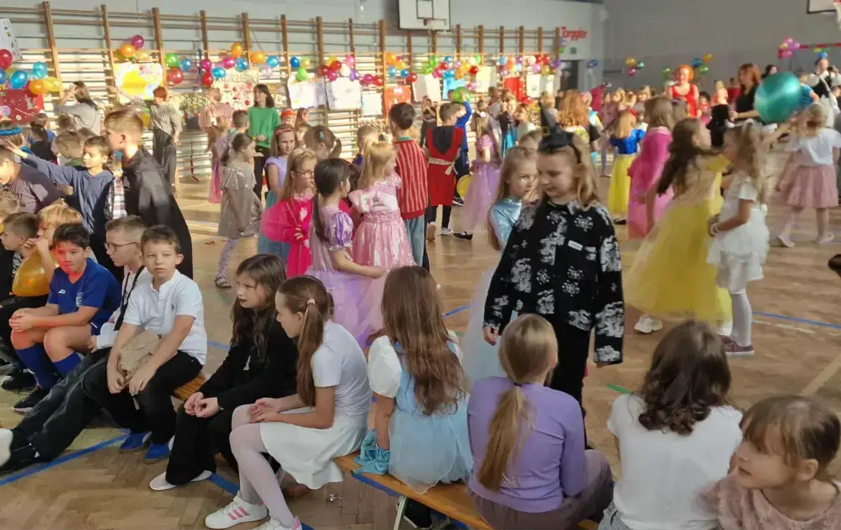 Uczniowie klas 0_3 w przebraniach tańczą podczas balu andrzejkowego