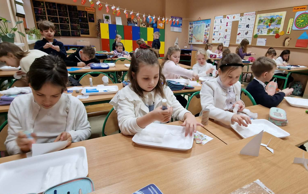 Uczniowie podczas wykonywania pracy plastycznej przedstawiającej zimę