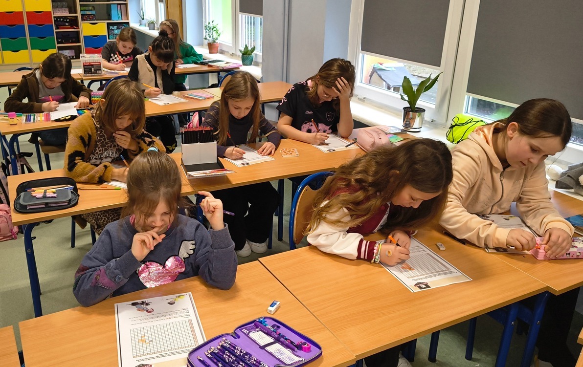 Zdjęcie przedstawia klubowiczów podczas wykonywania zadania z kodowania