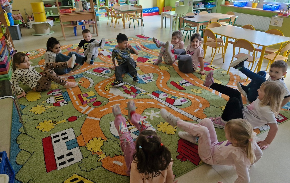 grupa w kole bawi się w zabawę Na dywanie siedzi jeż