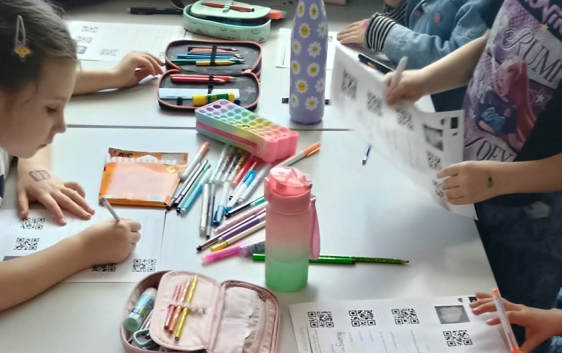 Uczniowie próbujący odkodować informacje ukryte pod kodem QR