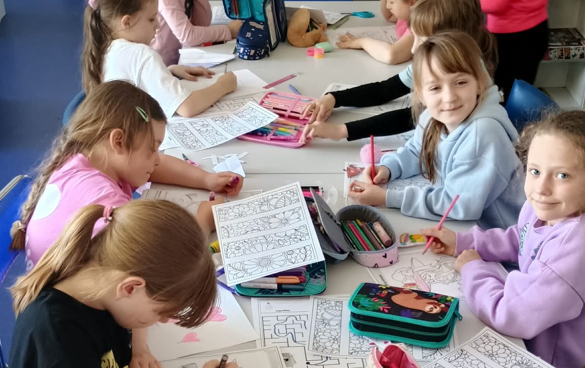 Dziewczynki z Koła Bibliotecznego uzupełniają karty pracy