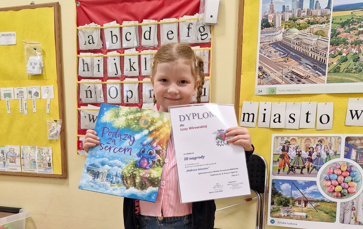 Lena prezentuje swoją nagrodę książkę i dyplom