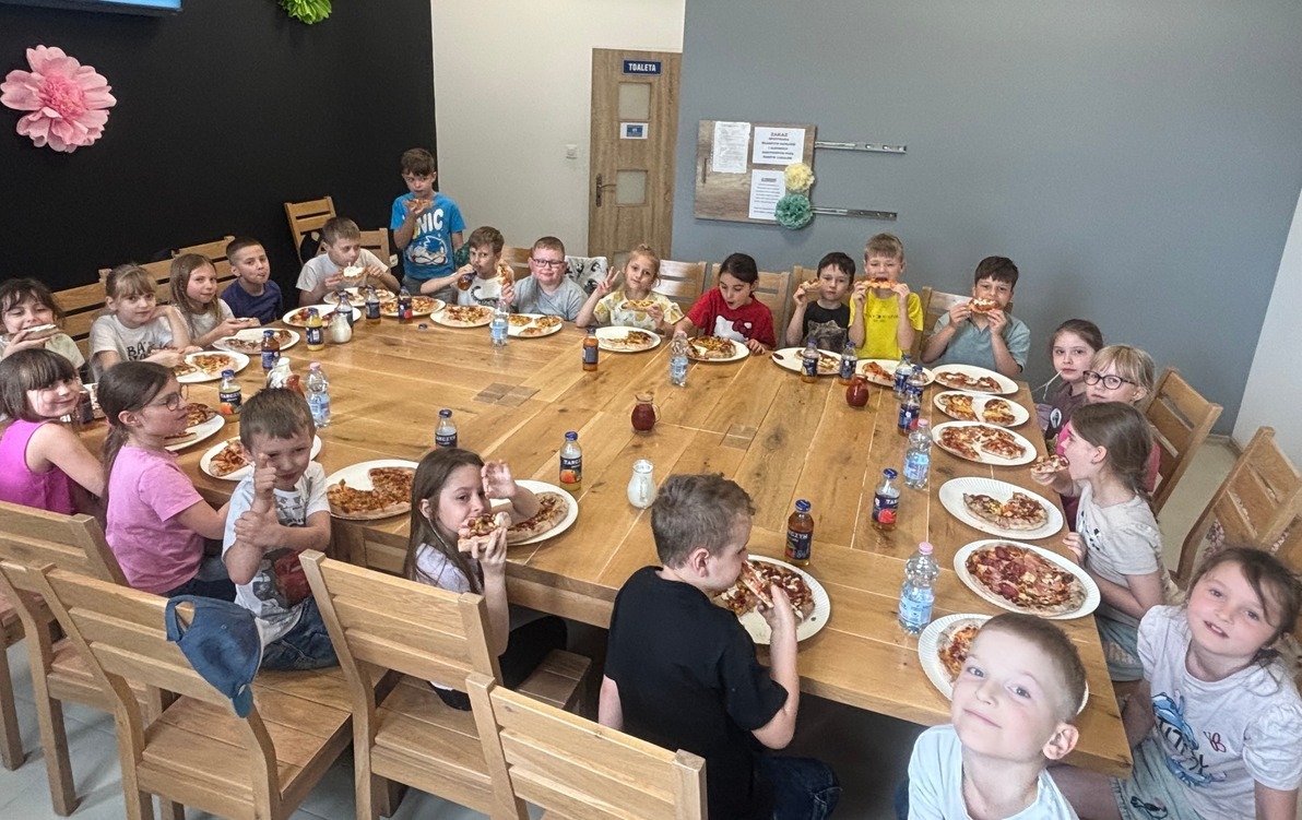 Dzieci jedzą pizzę