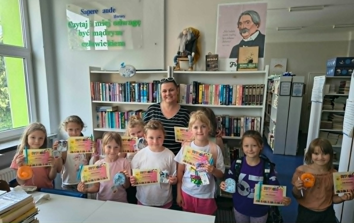 Uczestniczki Szkolnego Koła Bibliotecznego z klas pierwszych z dyplomami i drobnymi upominkami