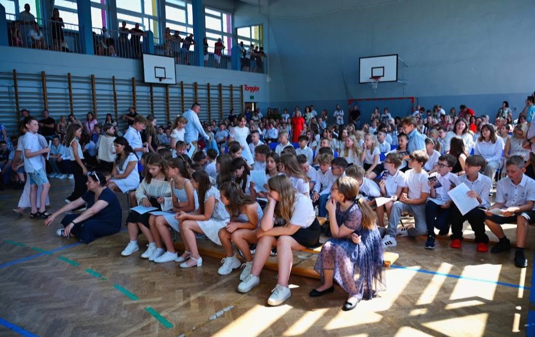 uczniowie zgromadzeni w sali gimnastycznej podczas uroczystości zakończenia roku szkolnego