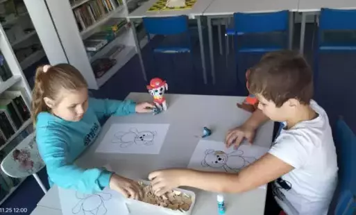 Dzieci wyklejają misia