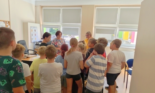 Grupa uczniów klasy 3C przekazuje pracownikom szkoły przygotowane przez siebie karteczki z dobrymi słowami.