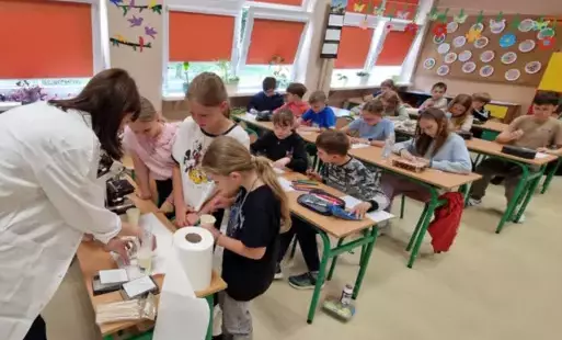 uczniowie przygotowują próbkę do badania pod mikroskopem