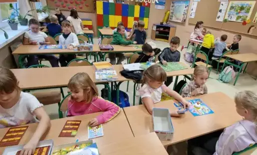 dzicie siedzą w grupach przy stolikach i grają w planszówki