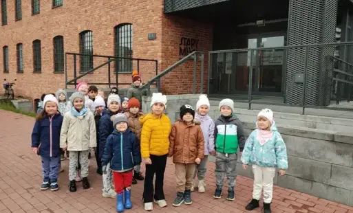 grupa przedszkolna stoi przed budynkiem starego mlyna w Zgierzu