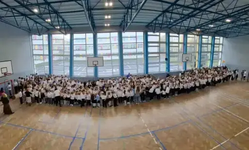 uczniowie klas 1 - 8 zgromadzona w sali gimnastycznej zdjęcia panoramiczne