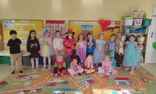 grupa przedszkola pozuje do zdjecia w bajkowych strojach