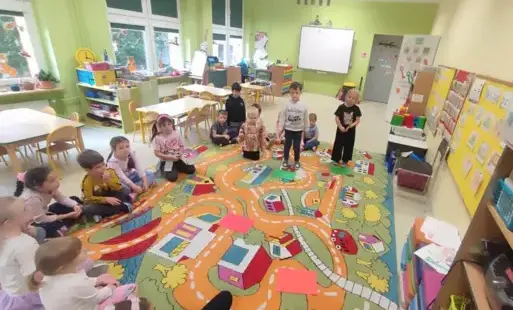 przedszkolaki siedzą na dywanie i bawią się w zabawę prawa- fałsz
