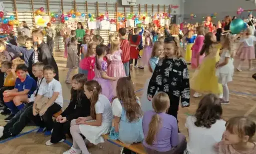 Uczniowie klas 0_3 w przebraniach tańczą podczas balu andrzejkowego