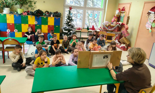 djęcie przedstawia klasę 2a podczas oglądania teatrzyku kamishibai pod tytułem „Opowieść o Czarnym Smoku