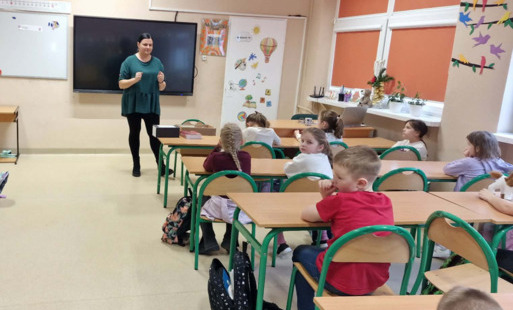 Pani bibliotekarka stoi przed grupą klasową