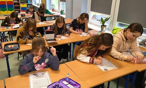 Zdjęcie przedstawia klubowiczów podczas wykonywania zadania z kodowania