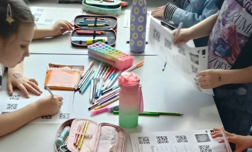 Uczniowie próbujący odkodować informacje ukryte pod kodem QR