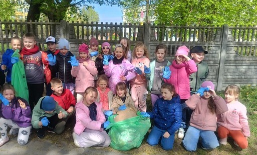 grupa uczniów w niebieskich rękawiczkach, pozująca do zdjęcia
