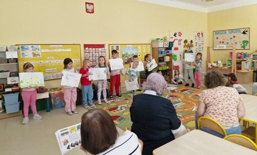 seniorki czytają wiersz Lokomotywa, a dzieci prezentują wykonane ilustracje