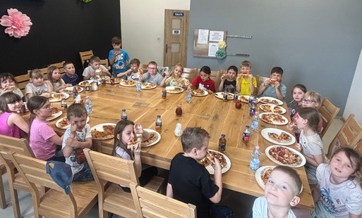 Dzieci jedzą pizzę