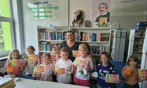Uczestniczki Szkolnego Koła Bibliotecznego z klas pierwszych z dyplomami i drobnymi upominkami