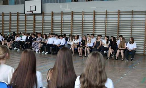 uczniowie klasy ósmej na tle drabinek podczas uroczystości zakończenia roku szkolnego klas ósmych