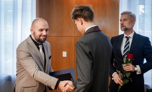 Aleks odbiera nagrodę od Przewodniczącego Rady Miasta. Na zdjęciu znajduj się również Prezydent Miasta