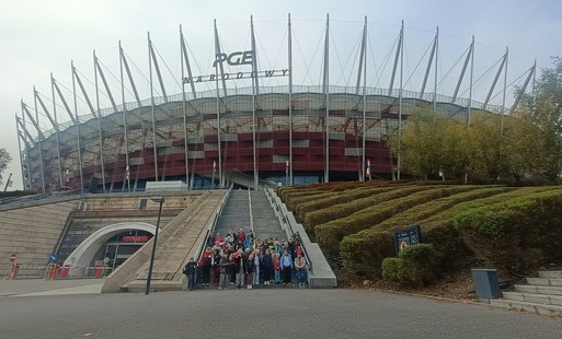 Uczniowie klas trzecich na wycieczce do Warszawy stoją przed Stadionem Narodowym
